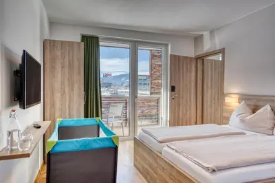 Ein Bett oder Betten in einem Zimmer der Unterkunft COOEE alpin Hotel Kitzbüheler Alpen
