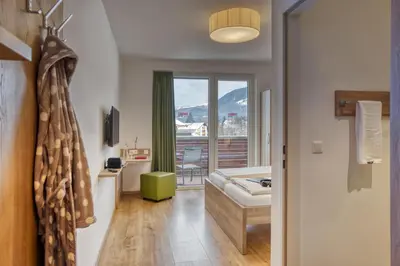 Ein Bett oder Betten in einem Zimmer der Unterkunft COOEE alpin Hotel Kitzbüheler Alpen