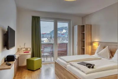 Ein Bett oder Betten in einem Zimmer der Unterkunft COOEE alpin Hotel Kitzbüheler Alpen