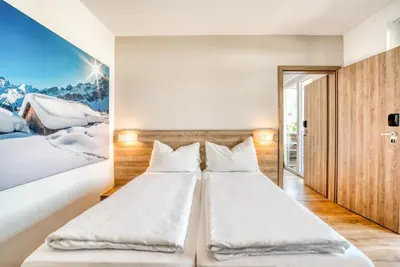 Ein Bett oder Betten in einem Zimmer der Unterkunft COOEE alpin Hotel Kitzbüheler Alpen