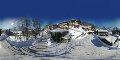 Modernes Chalet mit Terrasse und Parkplatz in den Alpen im Winter