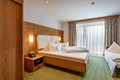 Ein Bett oder Betten in einem Zimmer der Unterkunft Alpenhof Hotel Garni Suprême