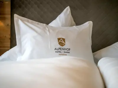 Ein Bett oder Betten in einem Zimmer der Unterkunft Alpenhof Hotel Garni Suprême