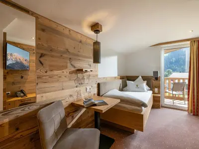 Ein Bett oder Betten in einem Zimmer der Unterkunft Alpenhof Hotel Garni Suprême