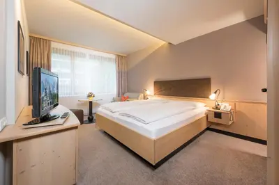 Ein Bett oder Betten in einem Zimmer der Unterkunft Aktivhotel Schweizerhof Kitzbühel