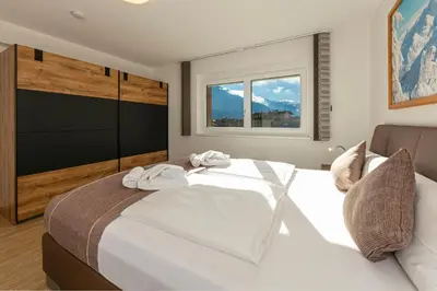Ein Bett oder Betten in einem Zimmer der Unterkunft H21 - Modernes Ferienhaus 145qm, 4SZ, Wellnessbereich mit Sauna und Dachterrasse mit Panoramablick, Kühlen und Heizen mit Geothermie
